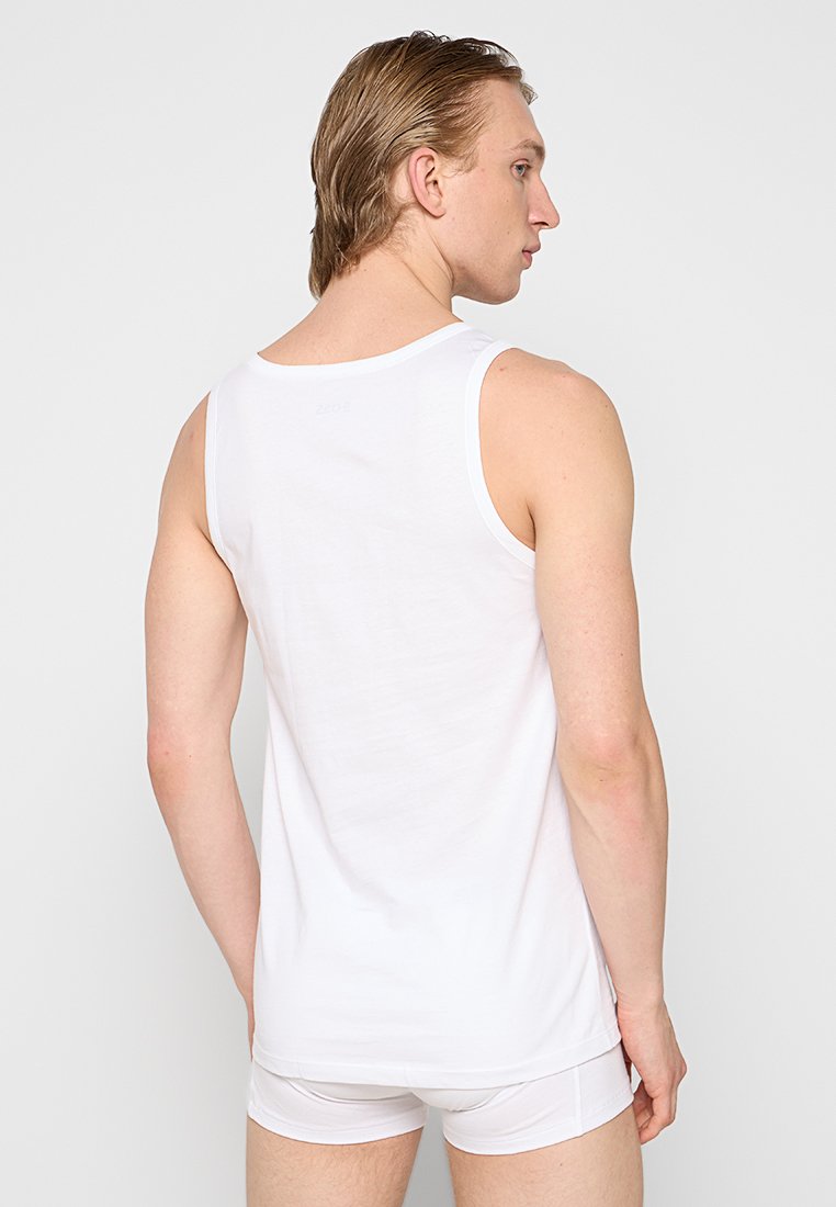 Weißes Baumwoll-Top mit Rundhalsausschnitt und ärmellosem Design, mit glatter Textur und Logodetail auf der Rückseite.