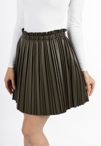 Olijfgroene geplooide faux leren rok met een elastische tailleband, met een gladde textuur en een uitlopende zoom.