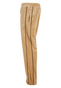 Tan velour joggers met zwarte zijstrepen, elastische tailleband en zijzakken. Heeft een klein logo op de bovenkant van de dij.