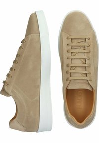 Beige Wildlederschuhe mit glatter Oberfläche, weißer Gummisohle und flachen Schnürsenkeln; zeichnet sich durch minimales Branding und eine runde Zehenform aus.