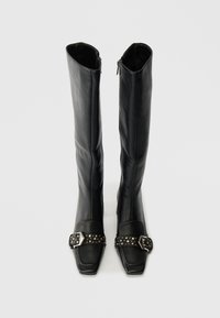 Black leather knee-high boots with square toes, a shiny buckle accent, and a studded strap. Smooth texture with a sleek design.