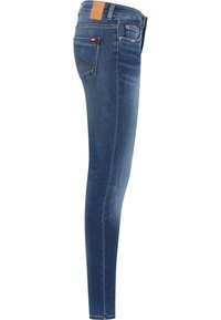 Jeans ajustados en denim azul oscuro; presentan un parche trasero de cuero marr�ón, un pequeño logotipo rojo y un diseño clásico de cinco bolsillos con detalles de costura.
