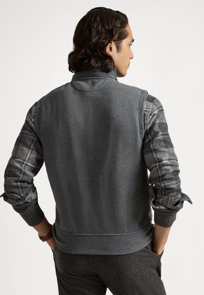 Grå sweatshirt med tekstureret krop og ternede flannelsærmer, med ribstrikkede manchetter og høj krave. Casual og funktionelt design.