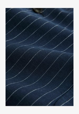 Marinblå tyg med vita smala ränder, slät textur och svarta knapppdetaljer, som visar upp en smidig, skräddarsydd design.