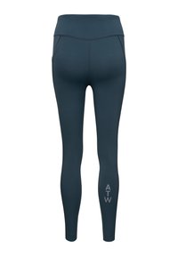 Hoge taille legging in donker teal, gemaakt van rekbaar materiaal. Heeft flatlock naden en een grijs "ATW" logo op het linkeronderbeen.