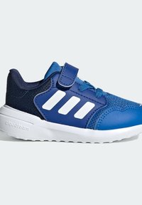 Niebieskie i granatowe buty sportowe z białą podeszwą, trzy paski Adidas, sznurowadła oraz rzep na jednolitym tle.