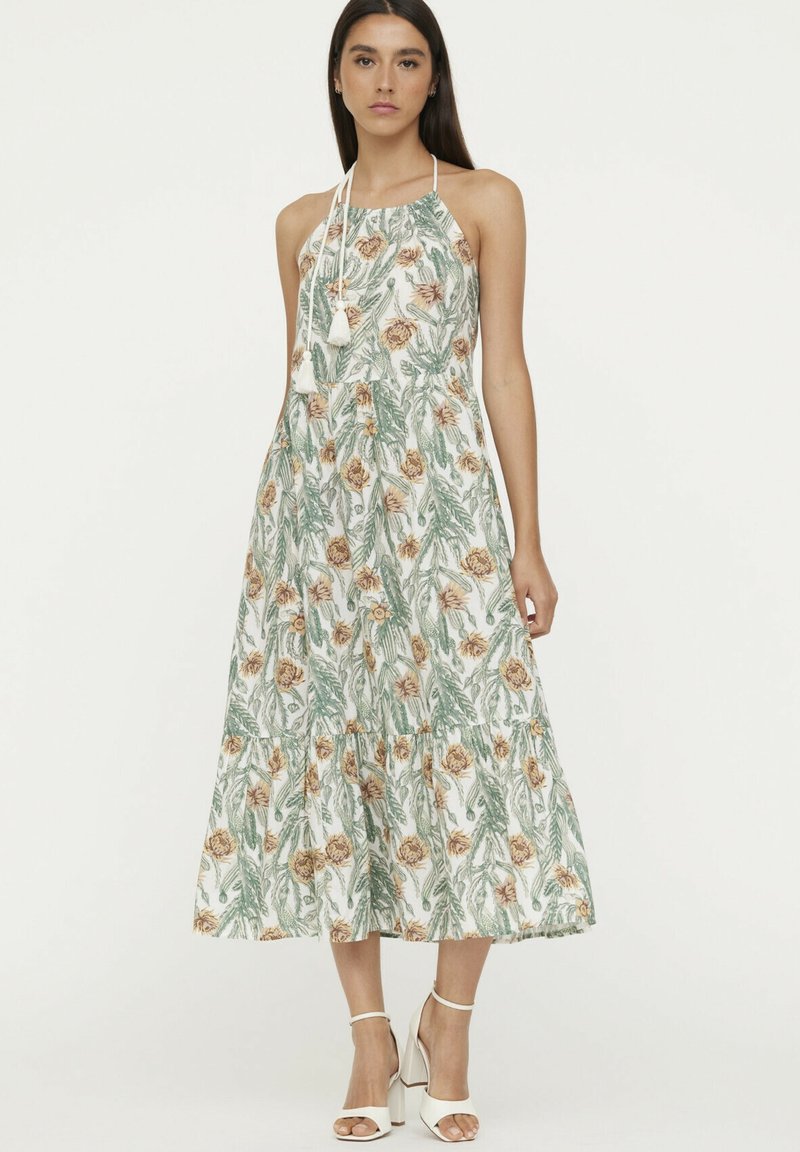 Blumenkleid in Midi-Länge in Weiß mit grünen Blättern und Pfirsichblüten. Mit Halterneck, schwingendem Rock und gestuftem Design. Verziert mit Quasten.