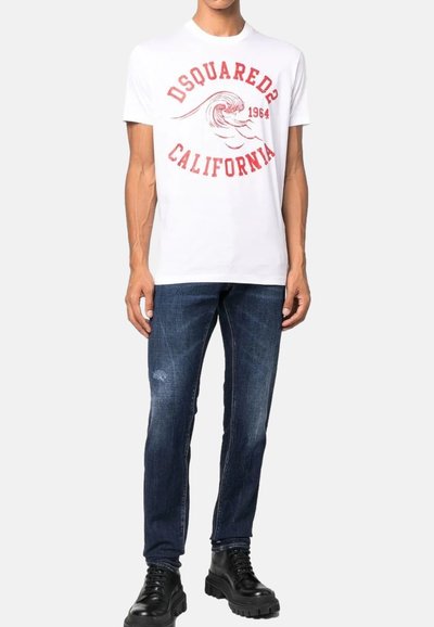 T-shirt en coton blanc avec une impression graphique rouge portant la mention "DSquared2 California 1964". Porté avec un jean bleu foncé et des bottes noires.