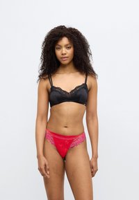Μαύρο δαντελένιο bralette με ρυθμιζόμενους ιμάντες, σετ με κόκκινα διάφανα εσώρουχα με δαντέλα και floral σχέδια στο ύφασμα.