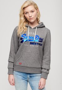 Sudadera gris con bolsillo frontal, cordón y logo "SuperDry" en letras azules brillantes. Tejido de mezcla de algodón; puños y dobladillo acanalados.