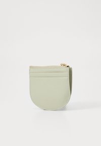 Borsetta rotonda in pelle verde con chiusura a zip e tasche esterne per carte. Presenta una finitura testurizzata e dettagli in metallo dorato.
