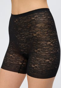 Μαύρο ψηλόμεσο εφαρμοστό σορτς με φλοράλ δαντέλα σε ένα άτομο, που εμφανίζει διαφανές περίπλοκο σχέδιο και στενή ελαστική μέση.