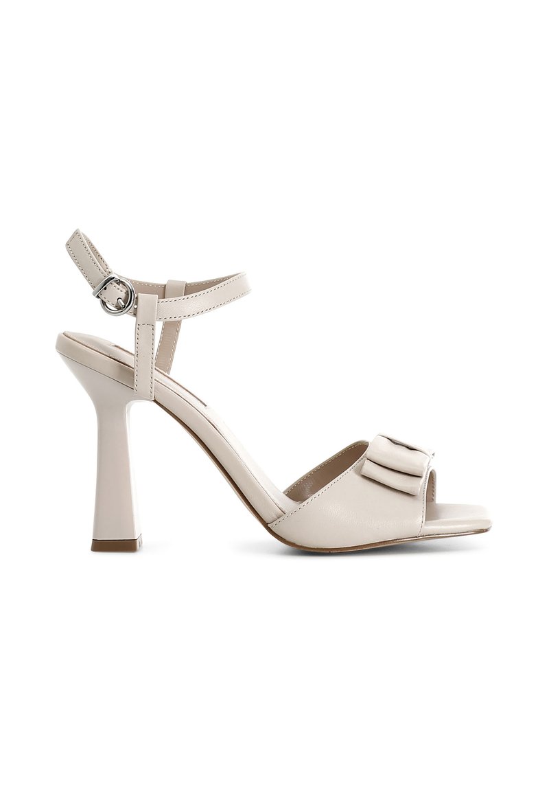 Beige sandály na vysokém podpatku s elegantním designem, otevřenou špičkou, sponou kolem kotníku a mašlí na svršku. Hladká kožená textura.