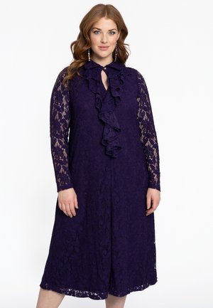Robe en dentelle violette avec des manches longues, un col à volants, une longueur au genou et des motifs floraux partout. Fermeture à boutons au niveau du cou.