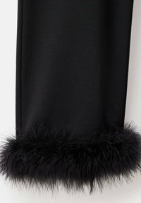 Pantalon noir avec un doux et duveteux bord en fourrure noire à l'ourlet, fabriqué en matériau lisse, présentant une coupe droite.