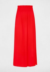 Gonna maxi rossa realizzata in tessuto leggero con vita arricciata. Il design presenta una silhouette fluttuante e un colore uniforme senza motivi.