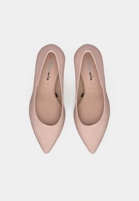 Ζευγάρι γυναικείων μπαλαρίνων σε ανοιχτό ροζ χρώμα με μυτερή μύτη και λείο φινίρισμα, σε θέα από ψηλά πάνω σε απλό ανοιχτό φόντο.