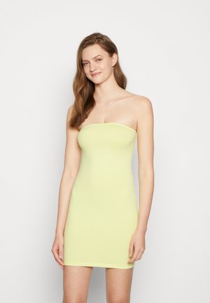 Vestido justo sem alças em amarelo brilhante, feito de um tecido elástico. Comprimento até ao joelho, com uma textura suave e design minimalista.