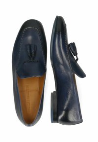 Mocasines de cuero azul marino con detalle de borlas en la parte delantera, puntera redonda y tacón plano. Textura suave y costuras tonales.