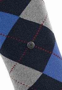 Męskie skarpetki w wzór argyle, z motywem granatowych, szarych i niebieskich diamentów z czerwonymi akcentami. Zawierają małe srebrne logo z boku.