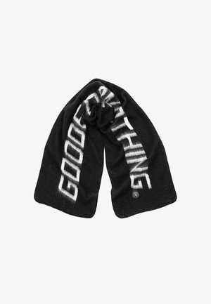 Zwarte sjaal met op één zijde in bold witte tekst "GOOD" en op de andere zijde "THINGS", gemaakt van zachte, gestructureerde stof, met een losse drapering.