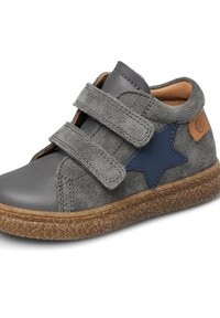 Scarpa in suede e pelle grigia con due strappi in velcro, accentata da una stella blu navy, suola marrone texturizzata, punta arrotondata e rivestimento interno beige.
