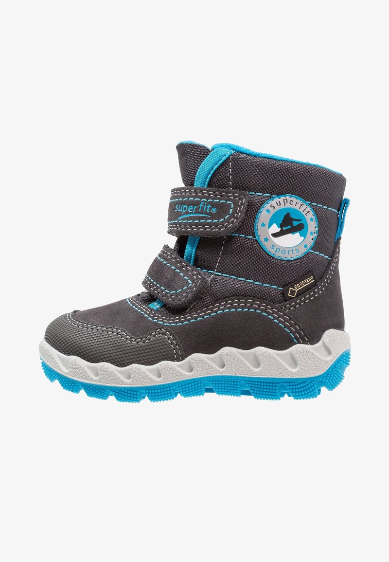 Botte grise pour enfants avec des accents bleus, bandes Velcro, tissu texturé, semelle blanche ondulée et un détail de logo rond sur le côté.
