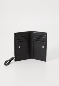 Black leather wallet with a zip-around closure, multiple card slots, and a snap button. Smooth texture with a simple, minimalist design.