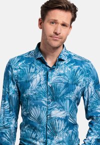 Blauw patroon shirt met een palmbladontwerp, gemaakt van lichtgewicht stof. Het heeft een kraag en knopen aan de voorkant.