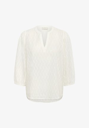 Balta pusiau permatoma bluzelė su subtiliu tekstūriniu raštu, apvaliu iškirpimu su V formos plyšiu, ilgomis pūstomis rankovėmis ir elastinėmis apykaklėmis.