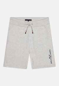 Pantaloni corti di cotone grigi con vita regolabile. Presentano un logo con testo blu scuro sul lato anteriore sinistro. Texture liscia, design fino al ginocchio.