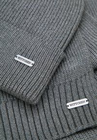 Berretti grigi lavorati a maglia con una texture a coste e una targhetta in metallo con inciso "WITTCHEN". Tessuto morbido che offre calore e comfort.