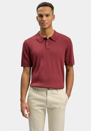 Bordeaux ribbet polo skjorte med korte ærmer, en lægkrave og to knapper. Bæres med beige bukser.