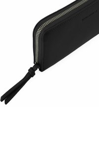 Portafoglio in pelle nera con finitura a trama, forma rettangolare, chiusura con zip argentata e dettaglio di nappina in pelle sul tirazip.