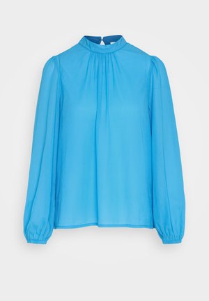 Lyseblå bluse lavet af glat stof, med en mandarin krave, lange puffede ærmer og en nøglehulslukning bagpå.