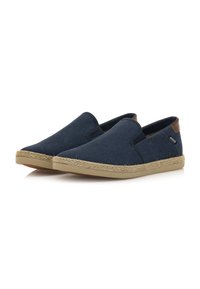Scarpe slip-on navy in tessuto testurizzato con pannelli elastici laterali e una suola intermedia in juta intrecciata beige. Dettaglio in pelle marrone sul tallone.