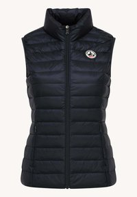Gilet imbottito nero con colletto alto, chiusura con zip frontale e motivo trapuntato orizzontale; presenta una toppa rotonda con logo nella zona sinistra del petto.