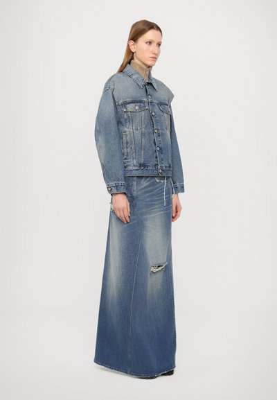 Denim jacket in light blue with classic collar, front pockets, and button closure; paired with a long, distressed denim skirt.