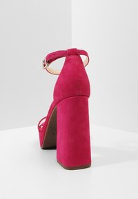 Fuchsia suède sandalen met brede blokhak, enkelriem en een gladde textuur; minimale accenten en een stevige zool.