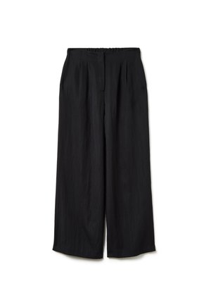 Pantalons larges noirs avec une taille élastique froncée, présentant des plis subtils sur le devant et un tissu léger et texturé.