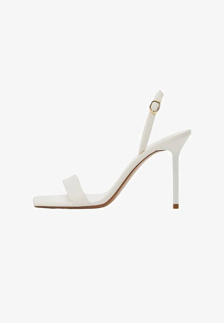 Sandale blanche à talon haut avec une fine bride à la cheville et une boucle dorée, bout ouvert, talon aiguille fin, vue de profil.
