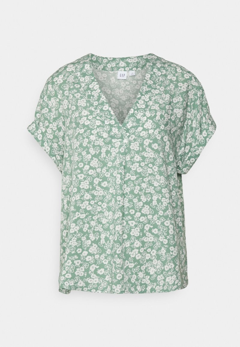 Blouse verte à manches courtes en tissu doux avec un imprimé floral blanc. Présente un col en V et une coupe décontractée.