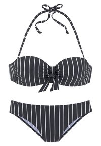 Bikini s crno-bijelim prugama koji se sastoji od bandeau gornjeg dijela s čvorom ispred i podesivim halter trakama, uparen s donjim dijelom niskog struka.