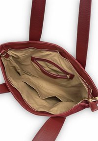 Intérieur d'un sac à main en cuir rouge montrant une doublure beige, une poche zippée et deux compartiments avec une finition texturée et des ferrures dorées.