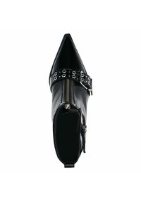 Black ankle boot with pointed toe, shiny patent leather, zip closure, and black leather strap featuring silver grommets and buckle detail.