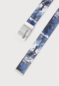 Κοντό καμπάνα σε μπλε και γκρι με αφηρημένα σχέδια. Διαθέτει ασημένια μεταλλική πόρπη με χαραγμένο το "Karl Lagerfeld Jeans."