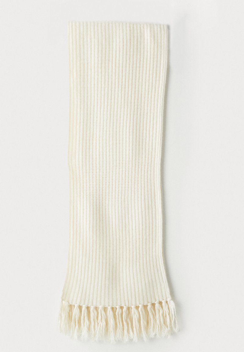 Bufanda de crema con textura acanalada y flecos en un extremo. Suave al tacto, de forma rectangular, ideal para superponer en climas fríos.