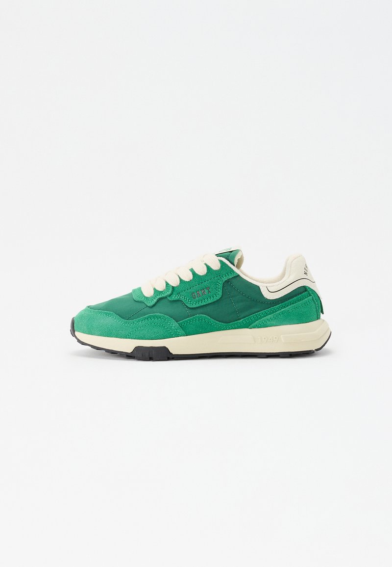 Green sneaker featuring a mix of suede and synthetic materials, textured panels, cream laces, and a white midsole with black outsole.