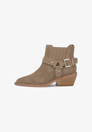 Bottines en daim marron avec un bout pointu, une sangle à boucle latérale, des coutures verticales et un petit talon carré avec une texture en bois.
