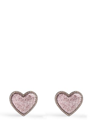 Paire de boucles d'oreilles en forme de cœur avec centres pailletés roses et petits strass autour sur fond blanc.